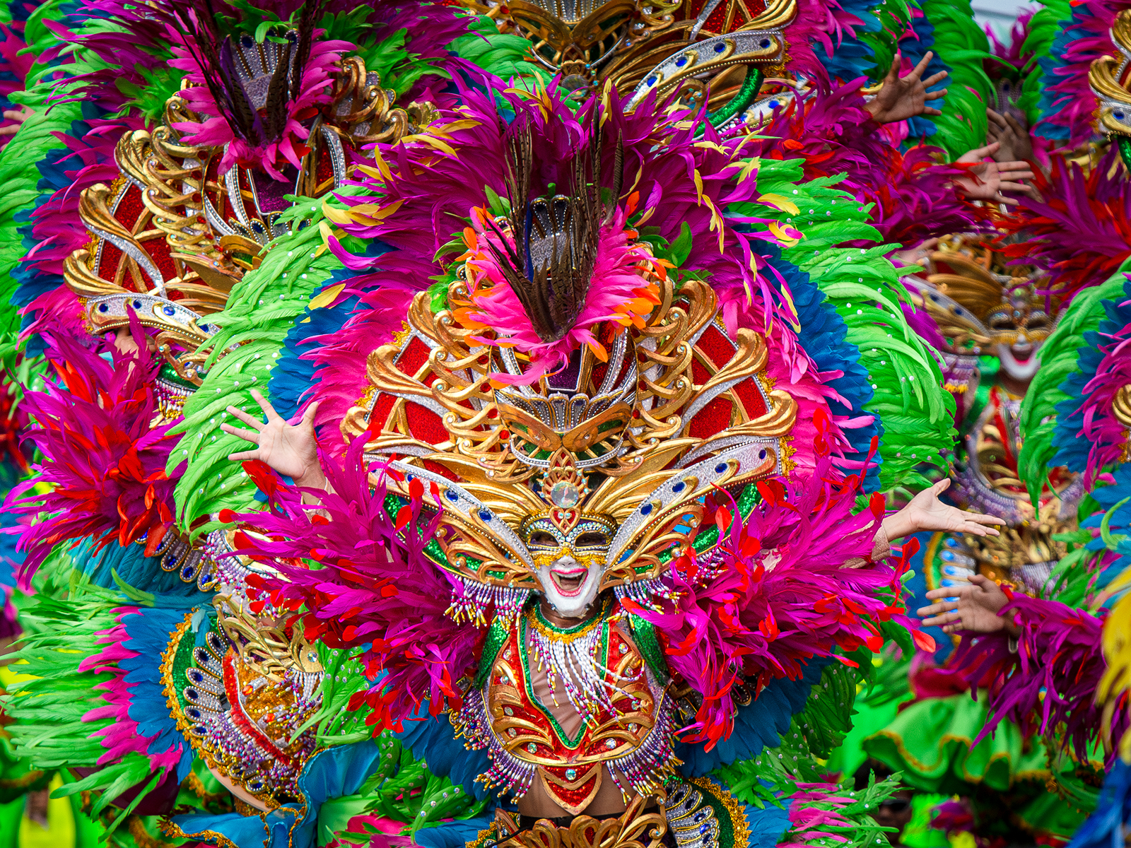 Feathered, sequined MassKara masks at street level