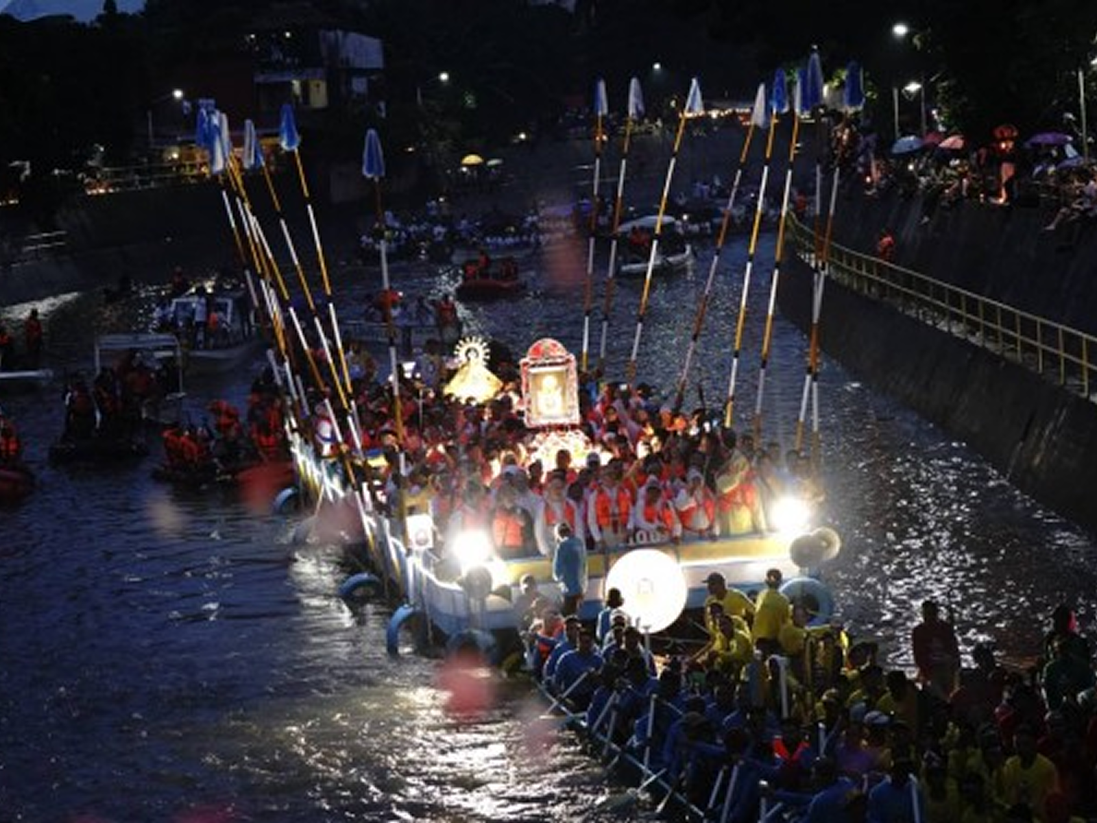 Devotees wading into the Bicol River alongside the boat